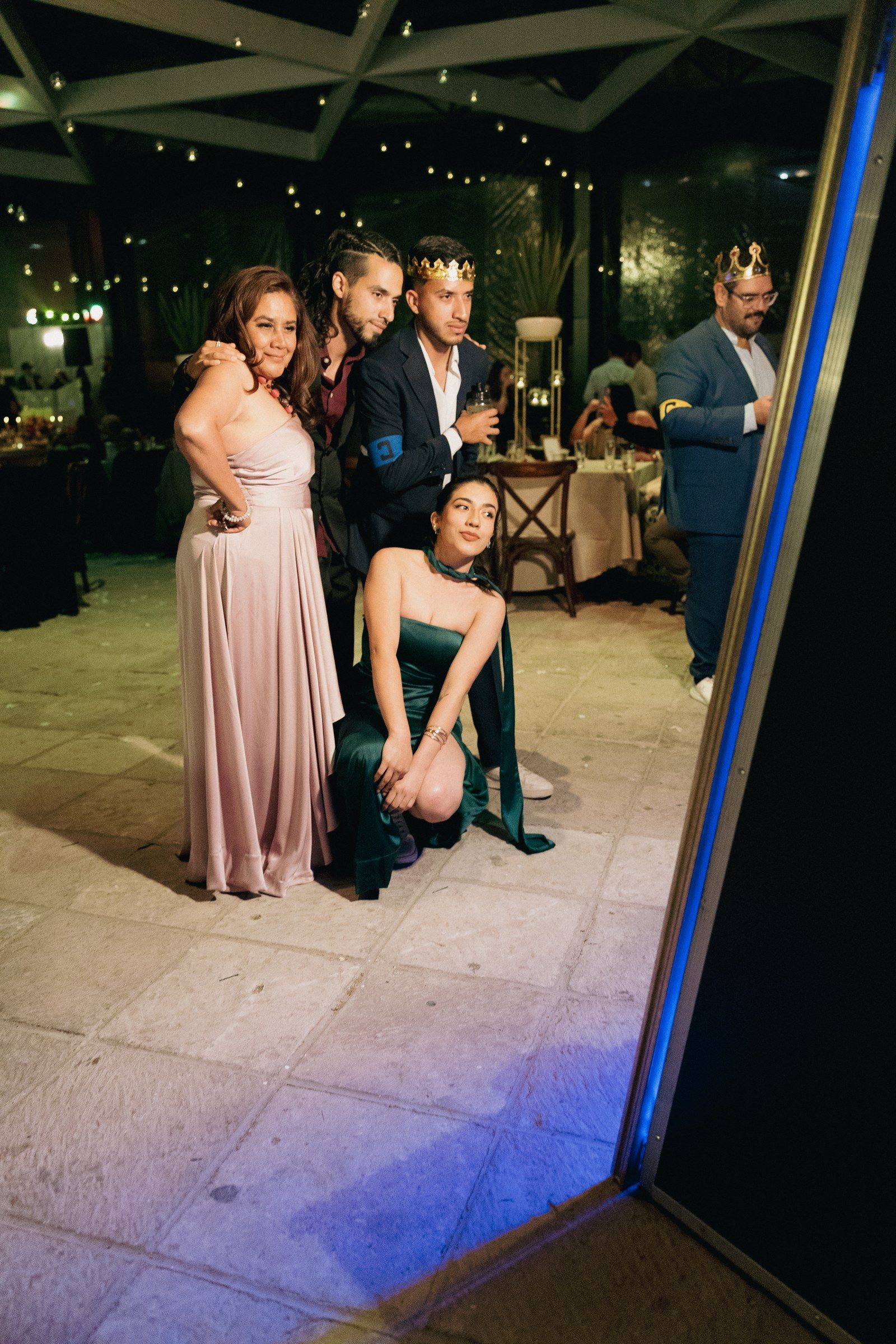 Amigos con coronas posando frente al espejo mágico en una fiesta en Querétaro