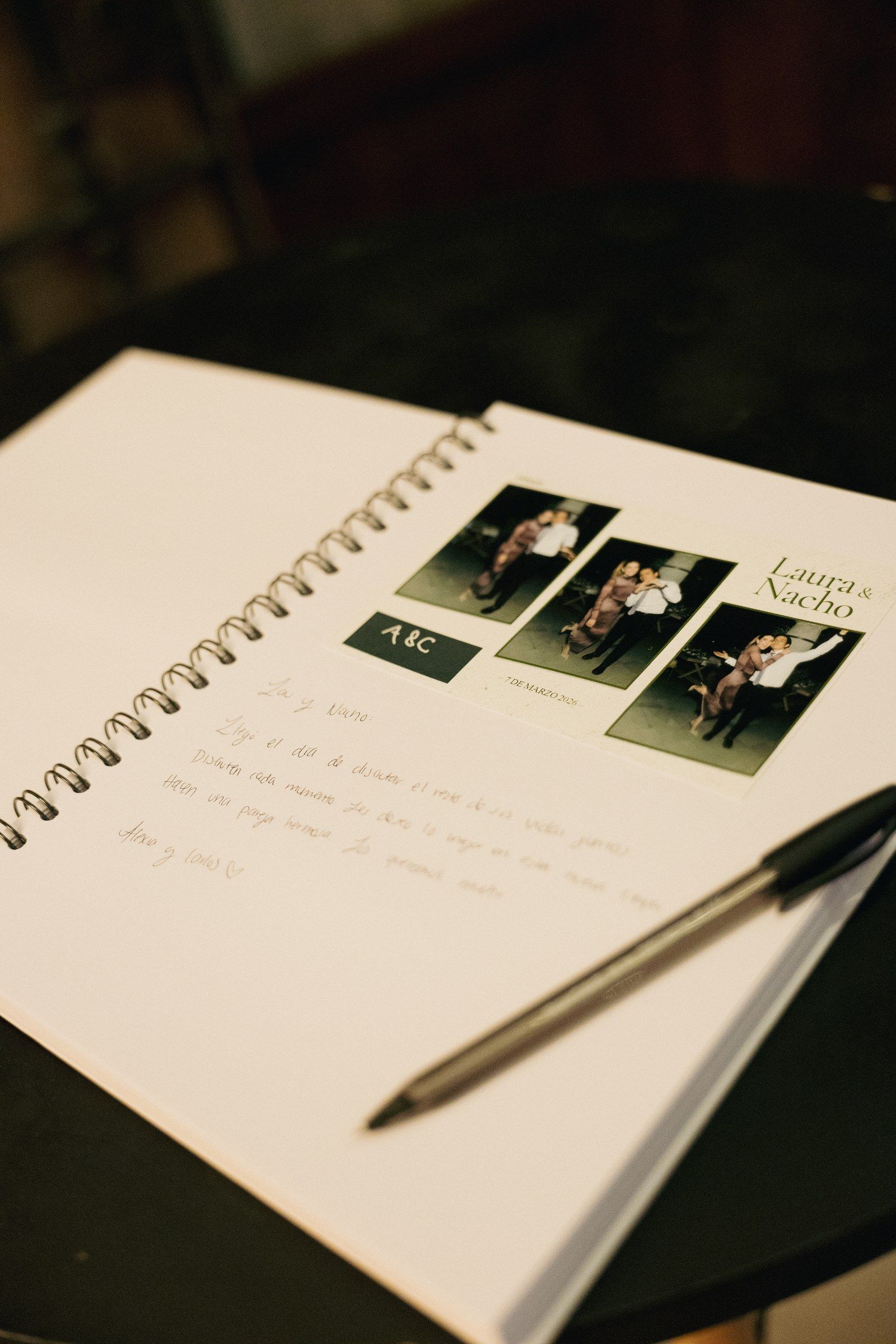 Libro de firmas abierto con la foto impresa del espejo mágico y un mensaje escrito a mano para los novios